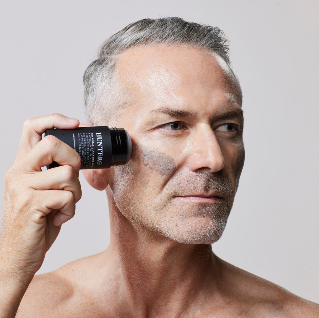 Hunter Lab Charcoal Cleansing Stick Man Applying Product with a neutral background