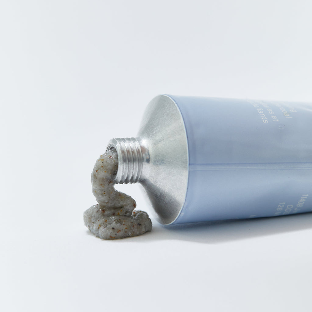 LESSE Refining Cleanser – face cleanser with charcoal and micro-exfoliating botanical shown dispensed from tube to highlight exfoliating cream  texture